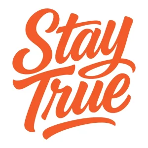 Bold orange script typography reading 'Stay True' in a hand-lettered style. Motivational and minimalist streetwear design.